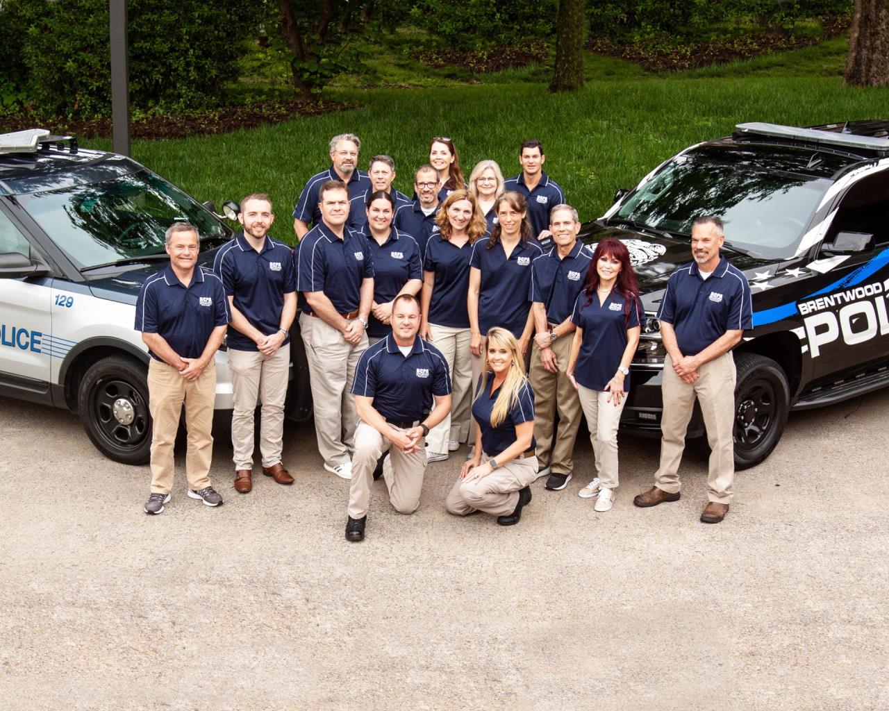 photo of graduates in front of police cars