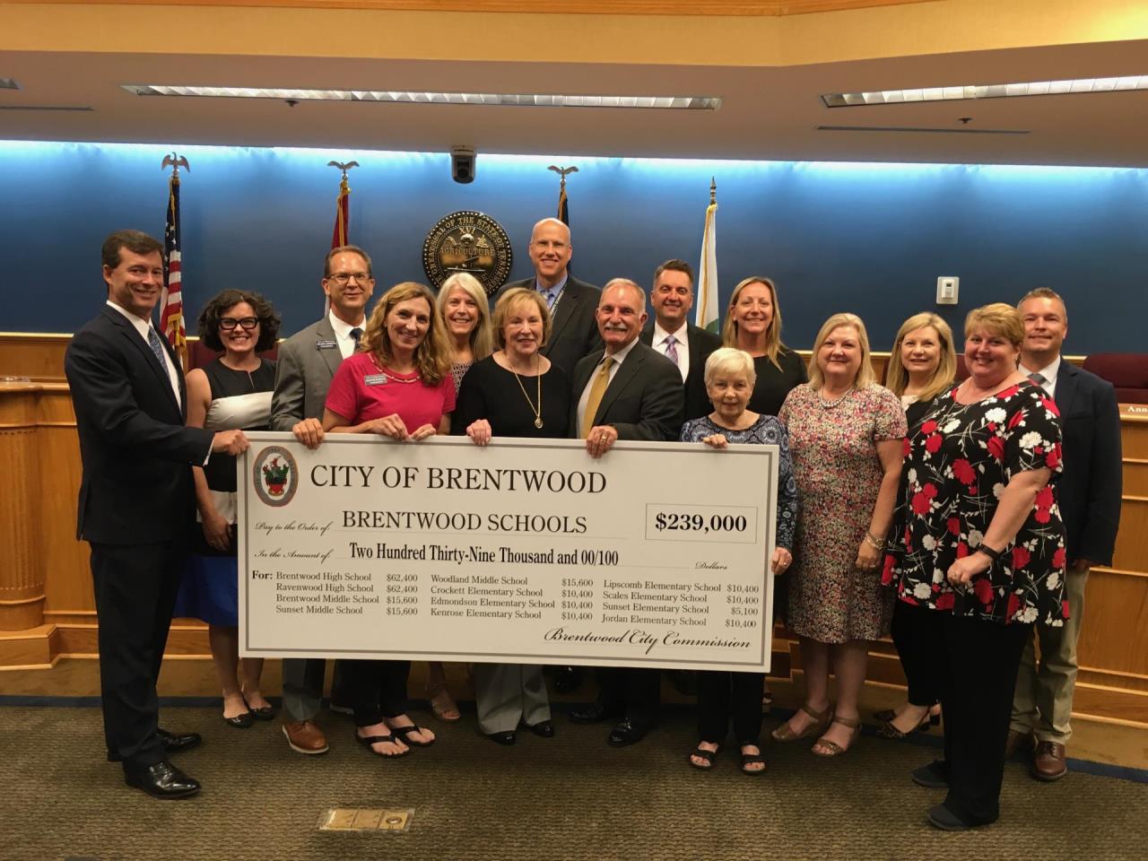 people standing with large check presentation