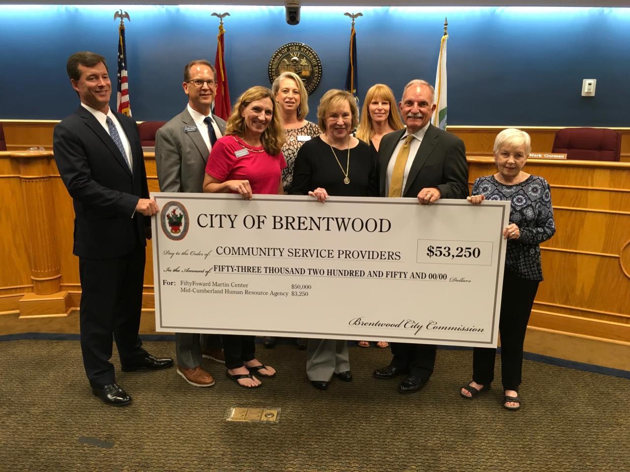 people standing with large check presentation