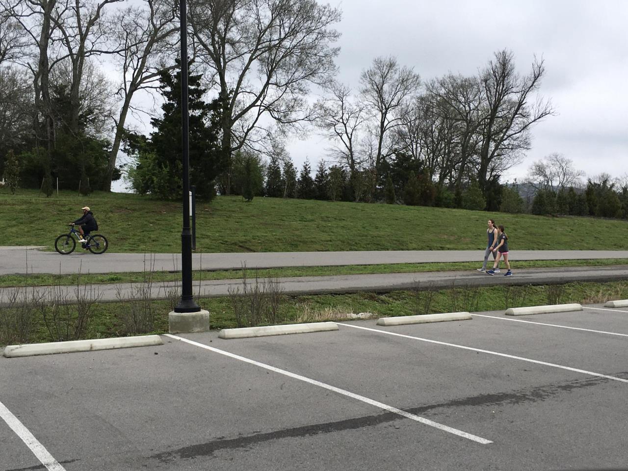 image of a cyclist and people walking six feet apart at a park