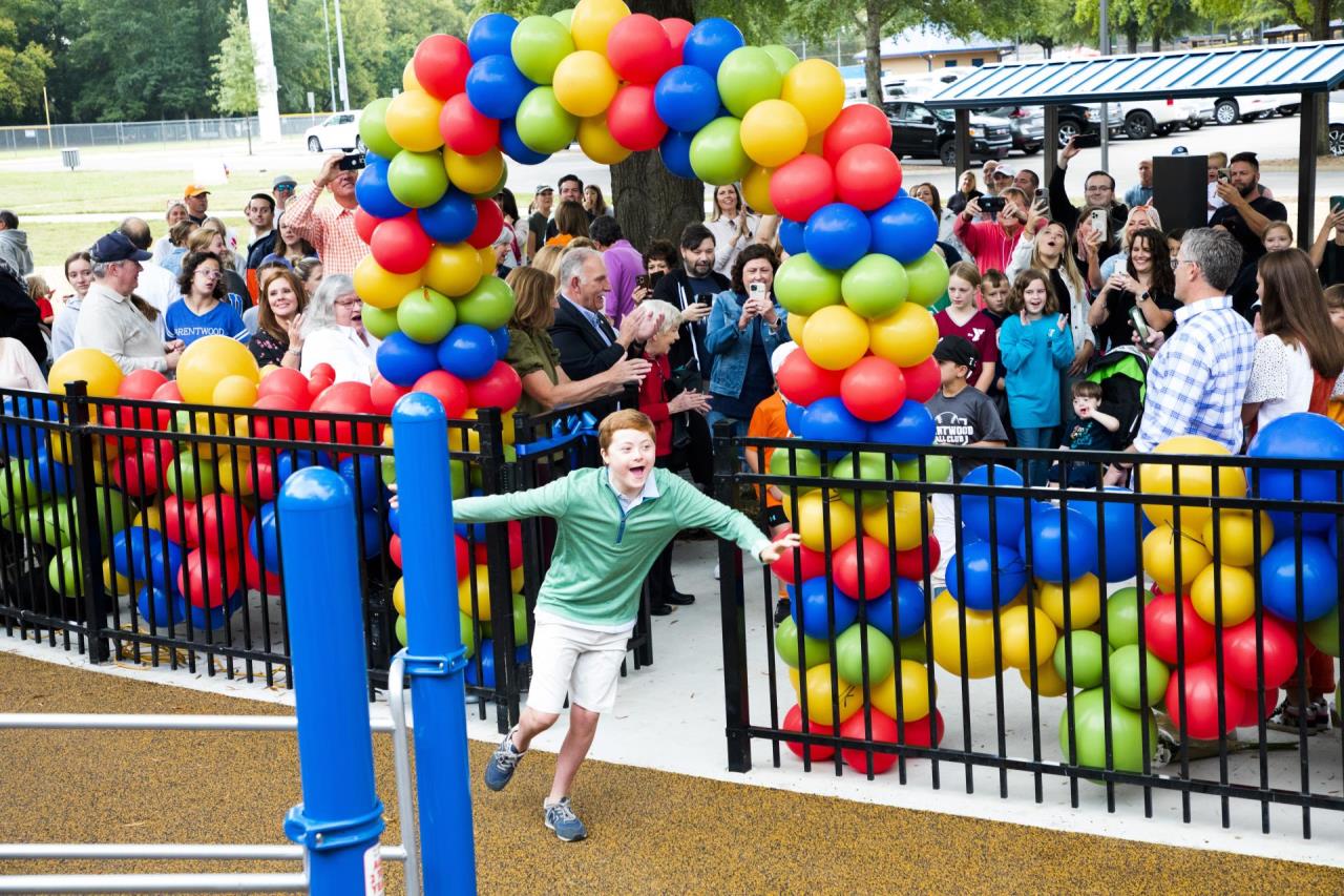 Miles Teller officially opens the playground by running through the front gate at the grand opening.